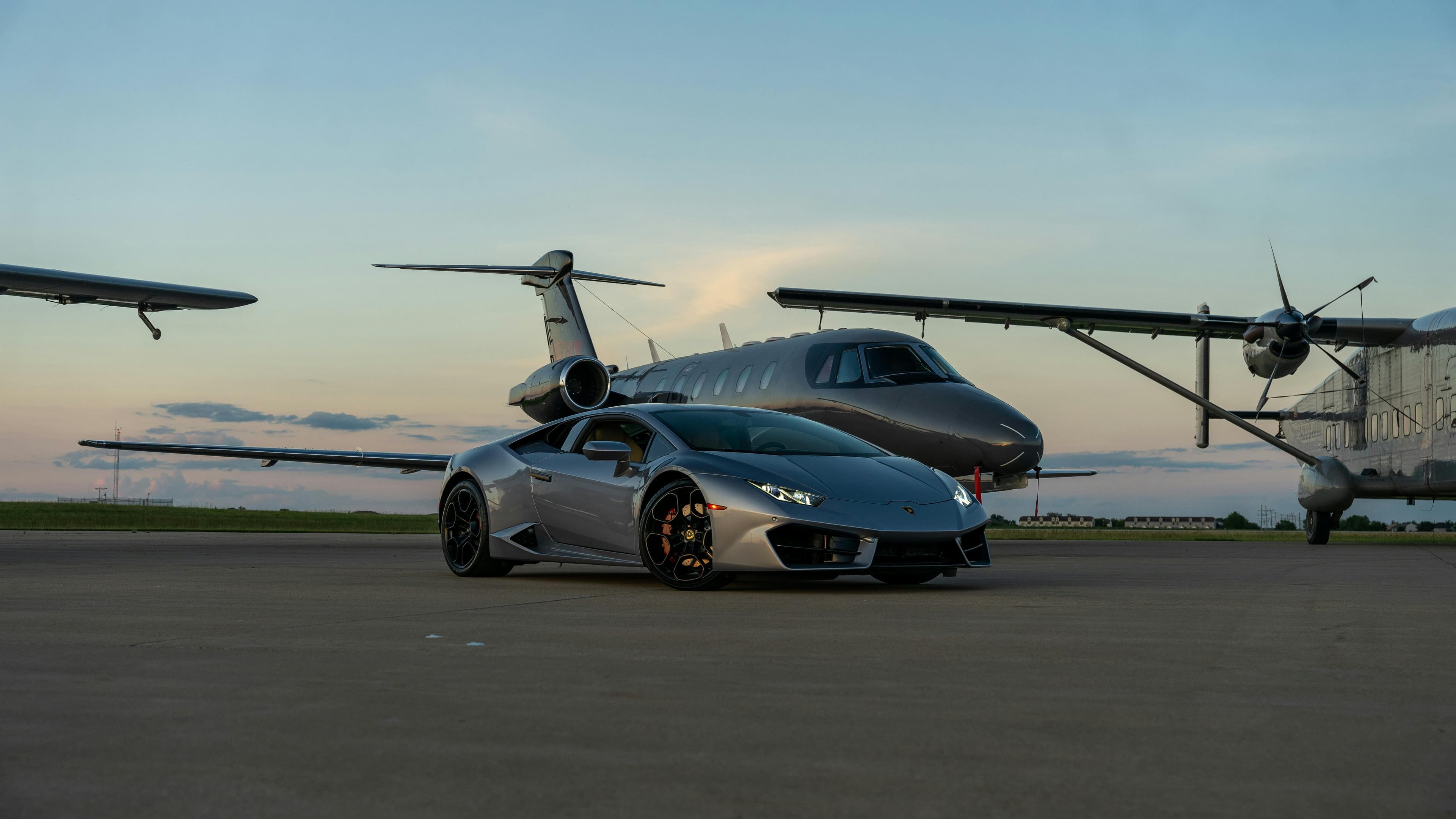 A light jet parked on the ramp at a regional airport with golf bags being loaded into the aft baggage compartment