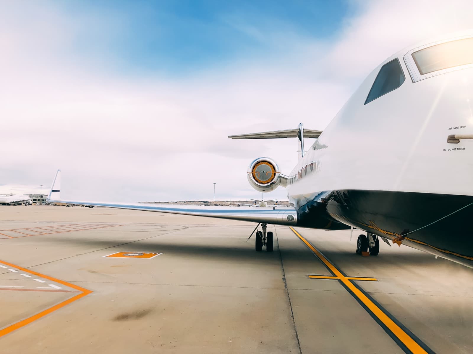 A light jet on the ramp at a South Florida executive airport at golden hour with palm trees in the background