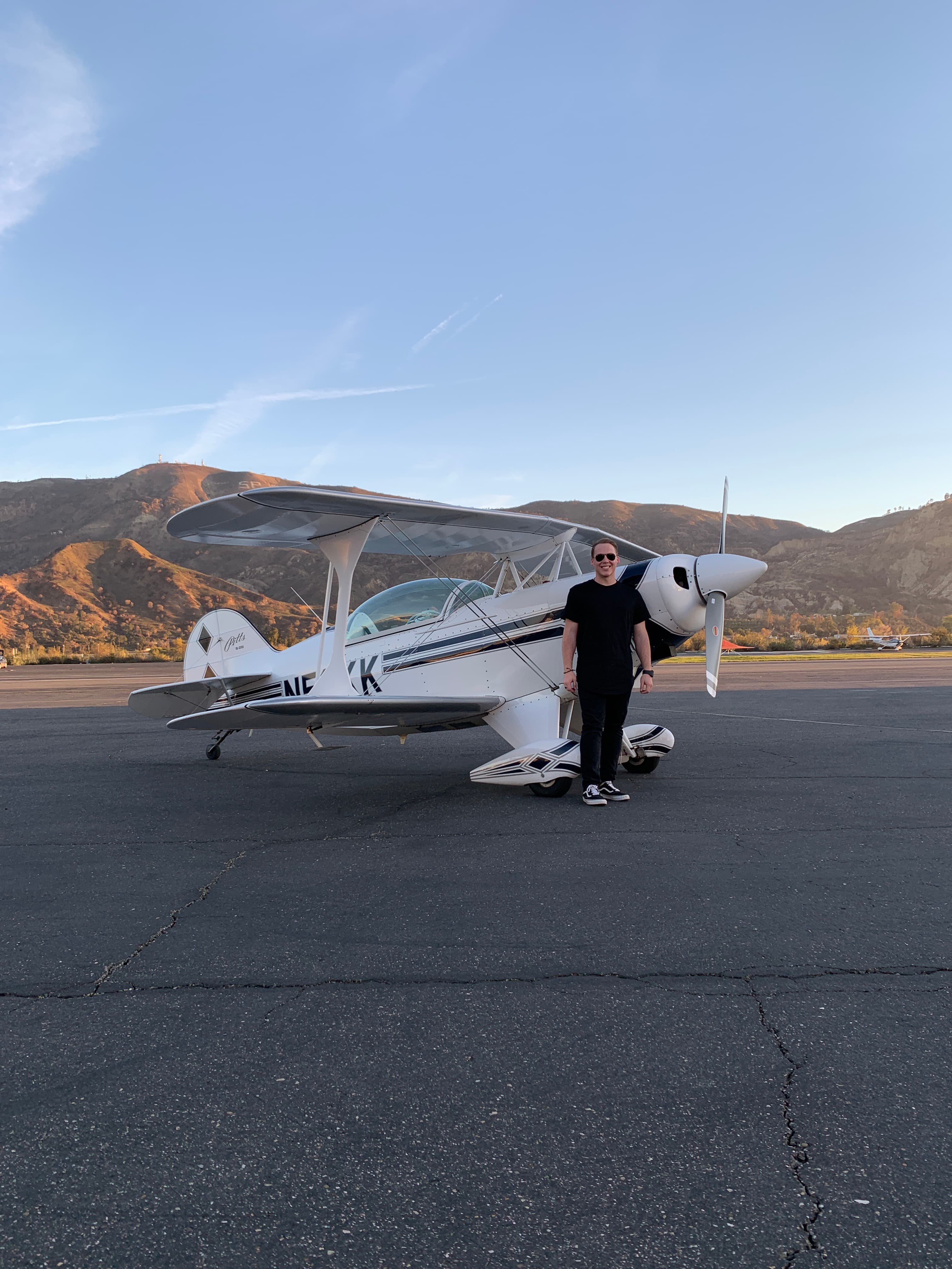 V. Cole Hambright beside a Pitts S2B biplane at sunset