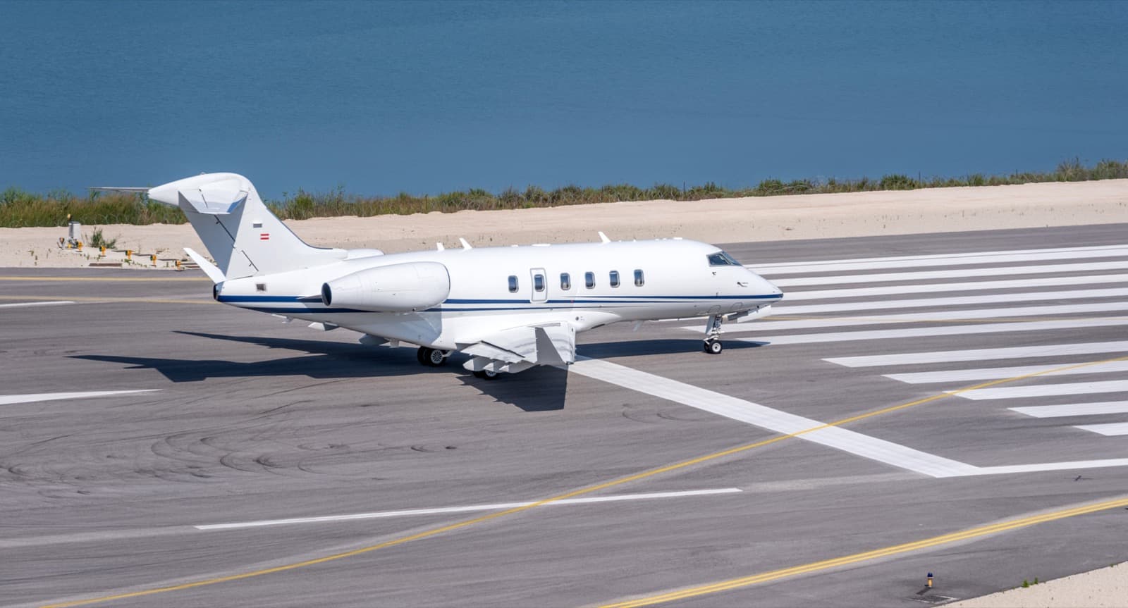 A midsize private jet on the ramp at a regional airport at golden hour with a single FBO building in the background