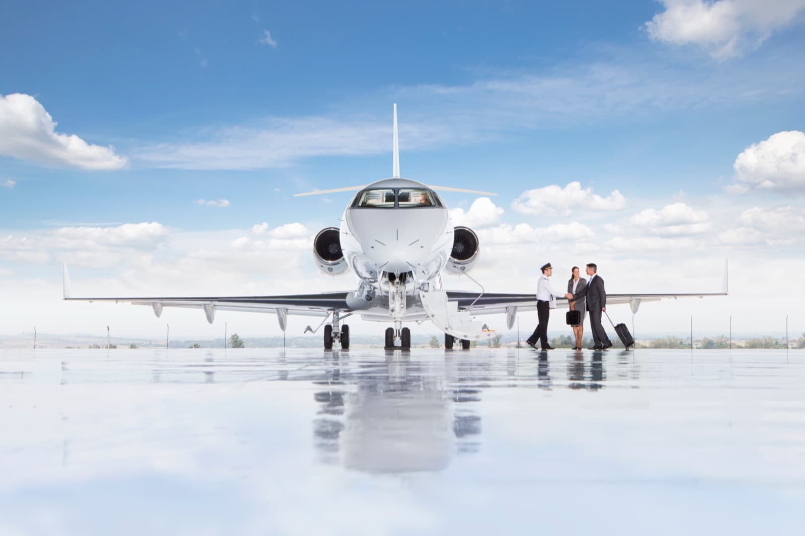 A midsize business jet parked on a quiet ramp at dusk with the airstair down